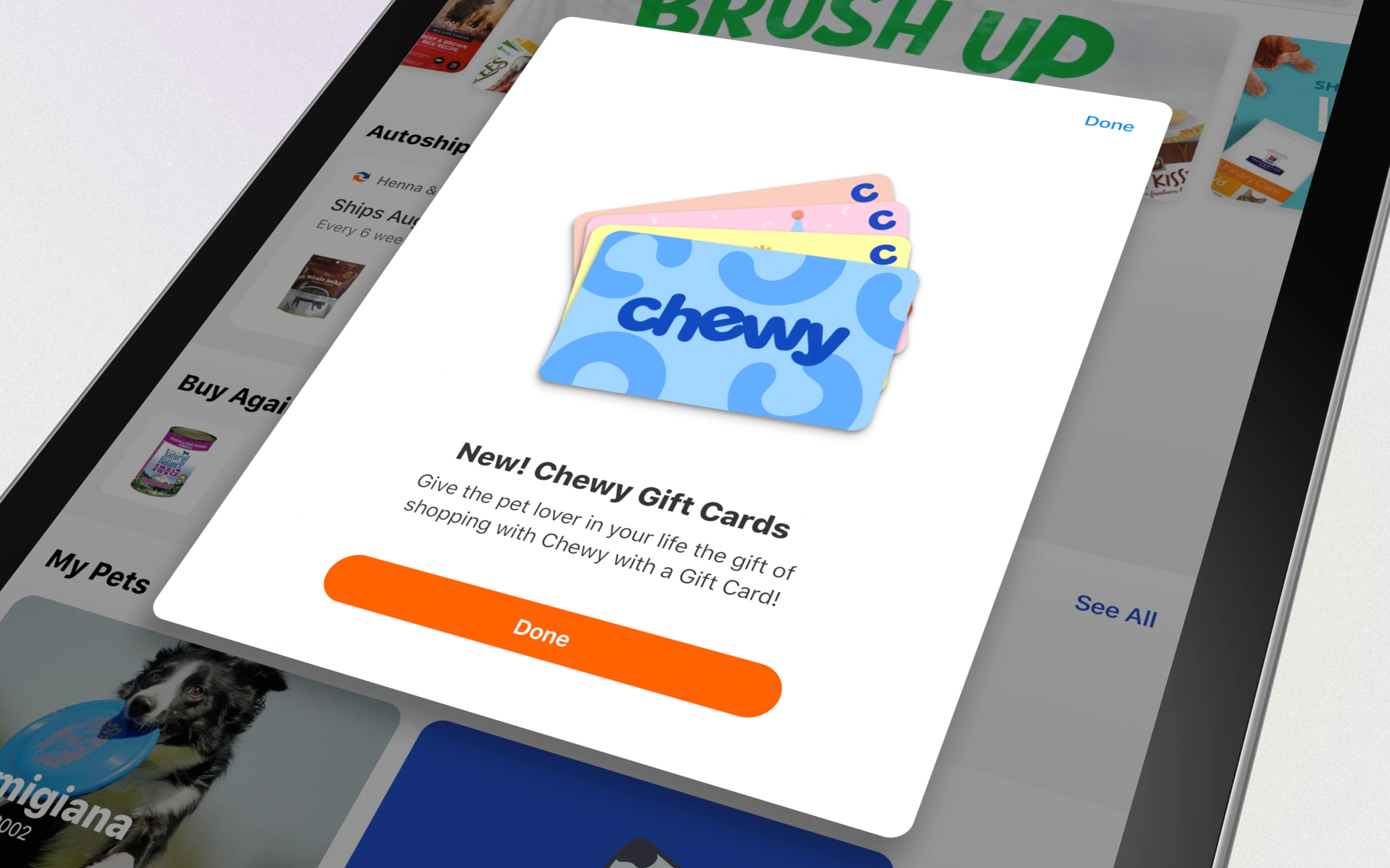 A tablet screen showing a popup for Chewy gift cards with a design featuring the Chewy logo.